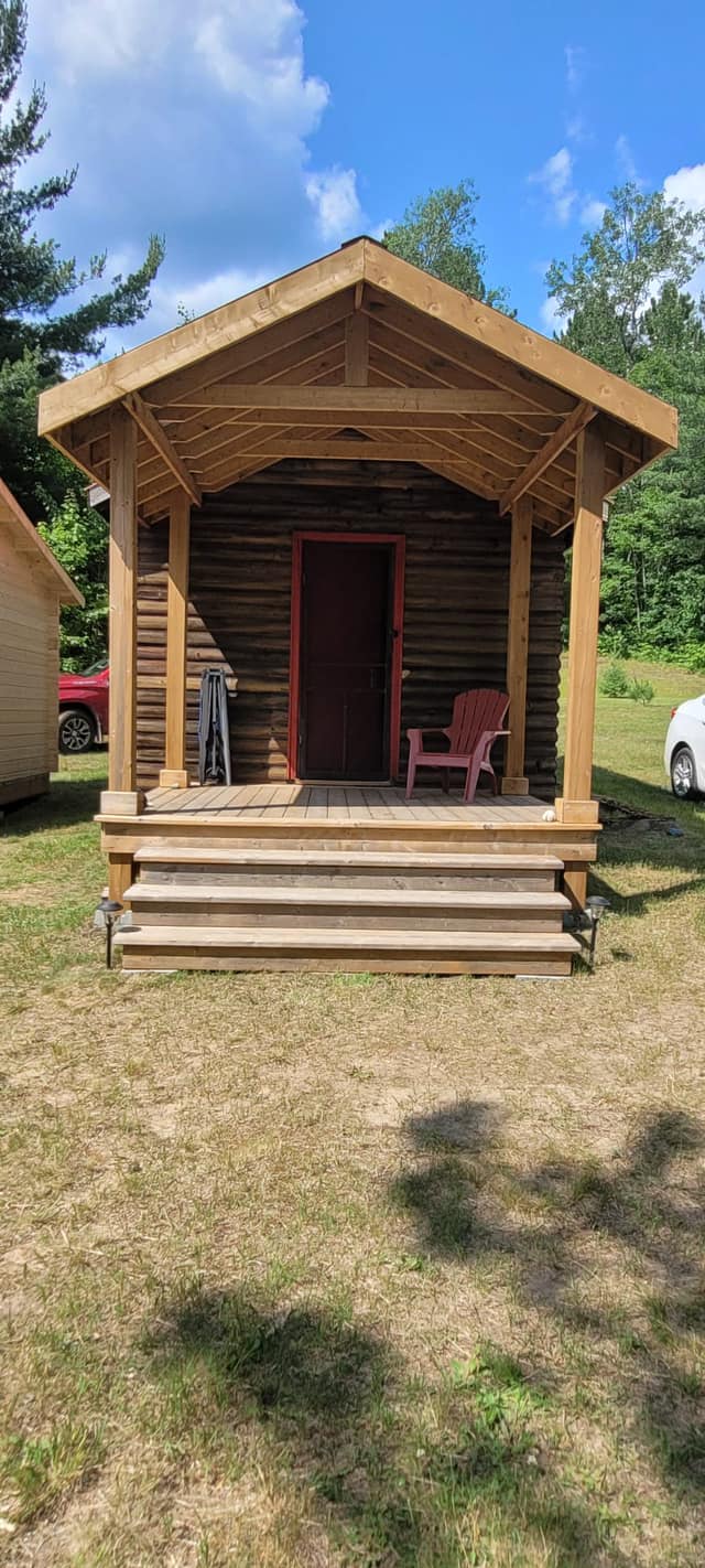 Front elevation of completed log cabin with covered porch
