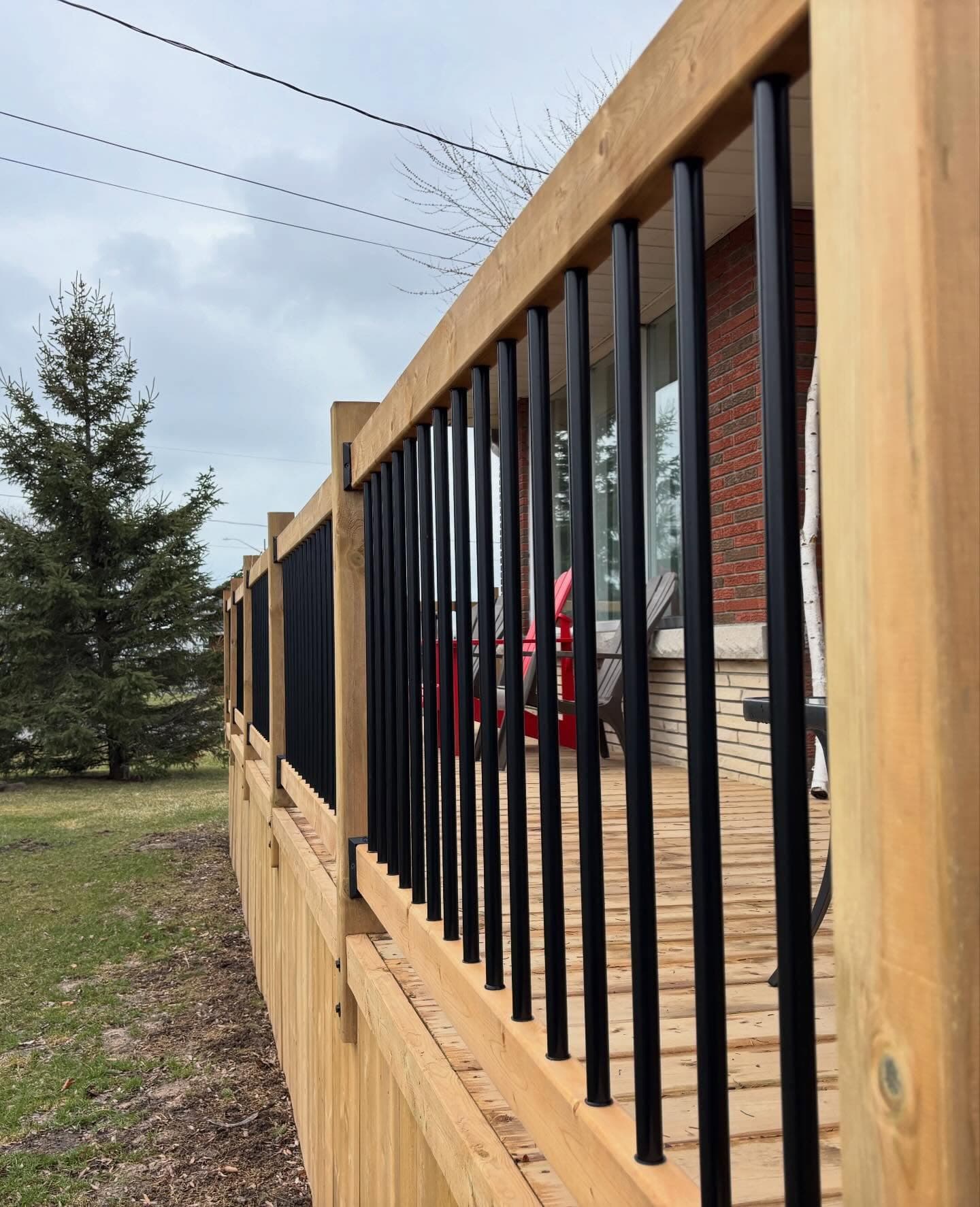 Custom deck with black metal railings, built by R&C Home Renovations
